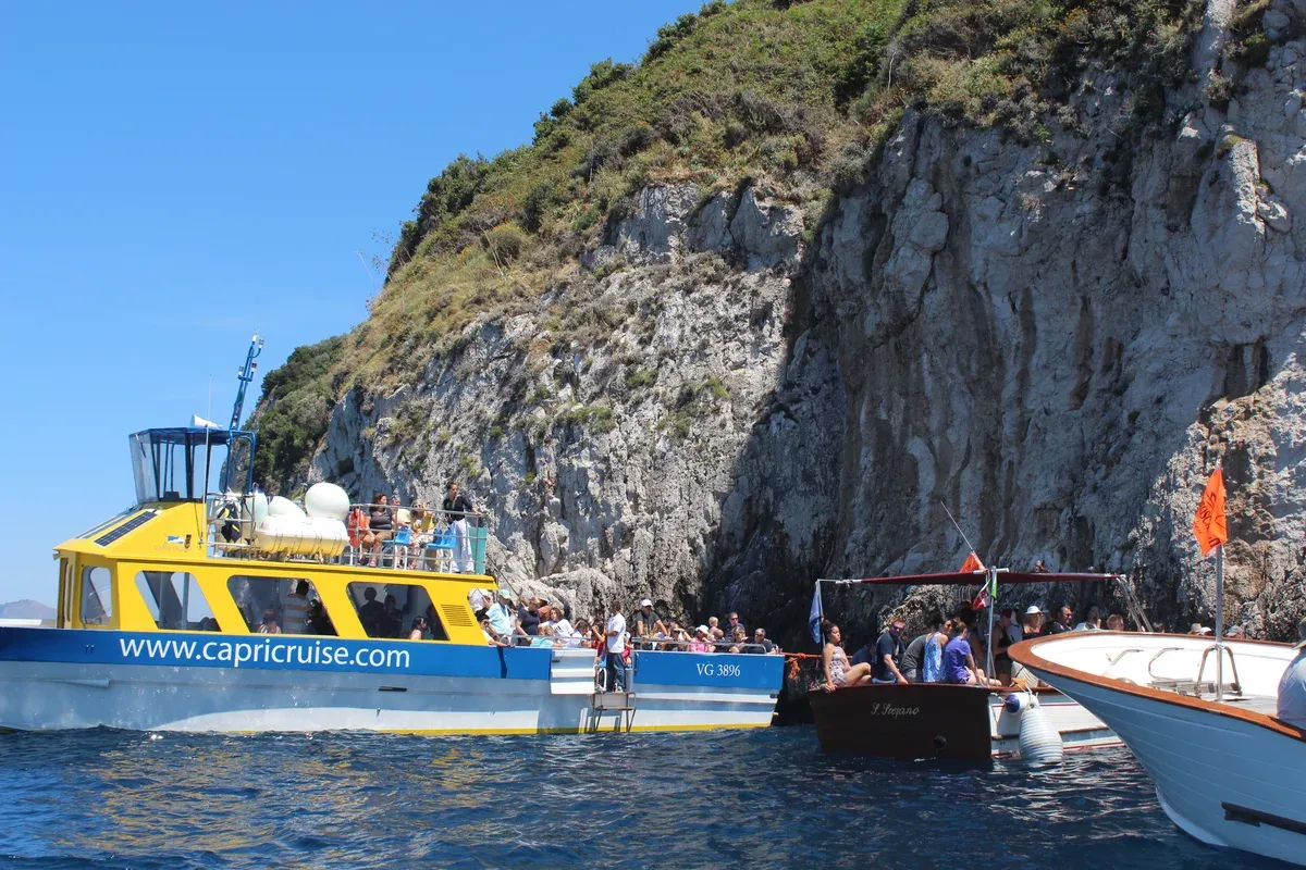 Rowboats queuing at the sea-level entrance of the Blue Grotto on the Capri Blue Grotto boat tour from Sorrento, Italy
