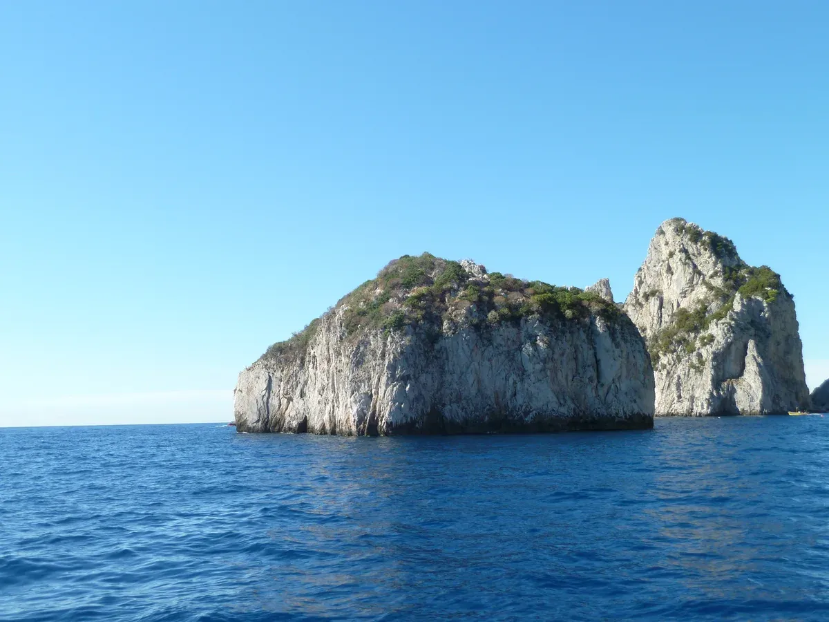 The Faraglioni sea stacks off the southern coast of Capri seen from a boat on an island boat trip with grottos around Capri, Italy