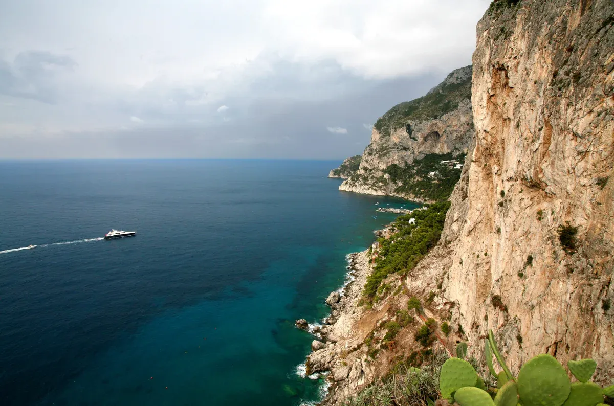 Boats anchored in the sheltered Marina Piccola bay below Capri town on a small group Capri island boat ride with swimming, Italy